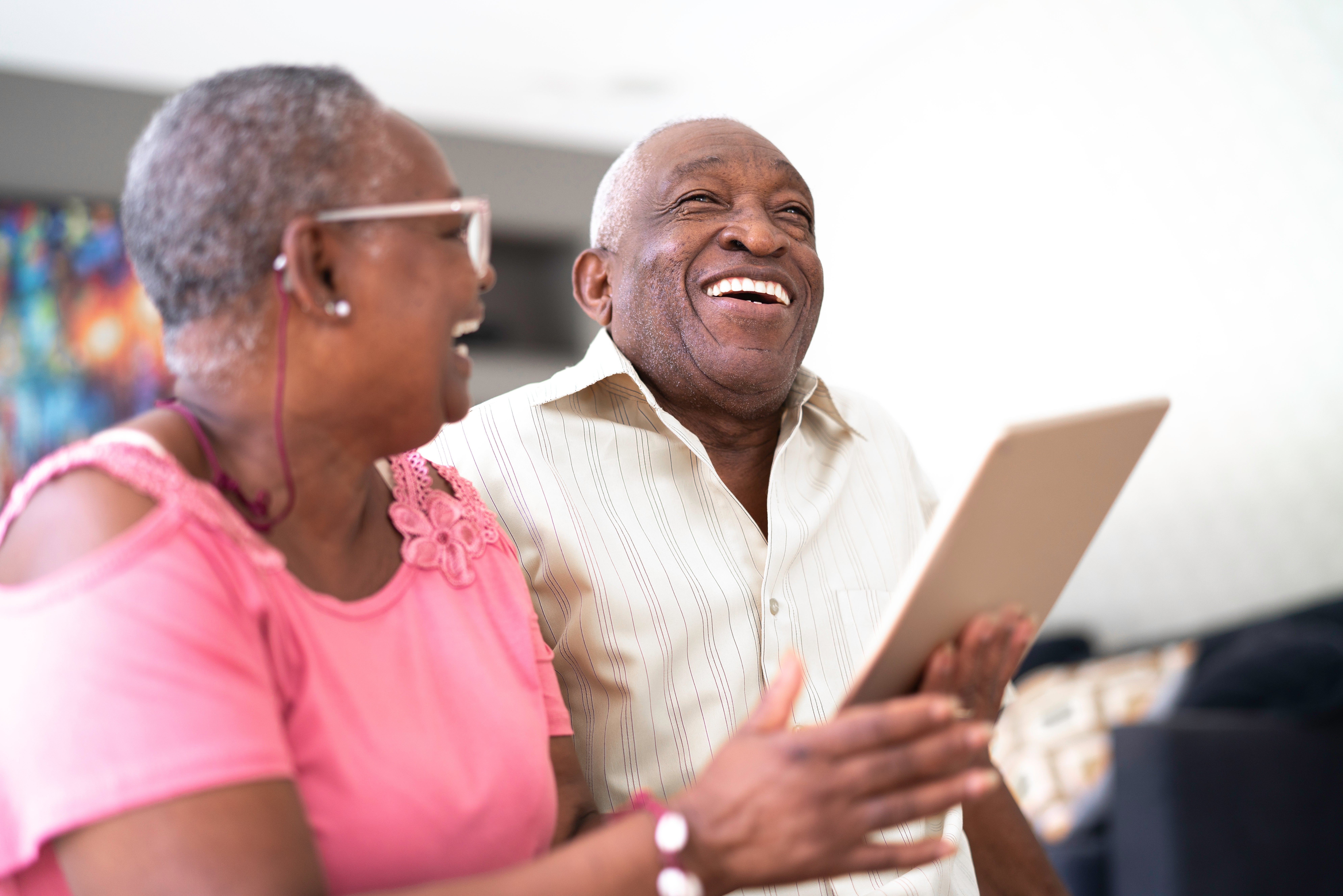 two adults laughing looking at paper