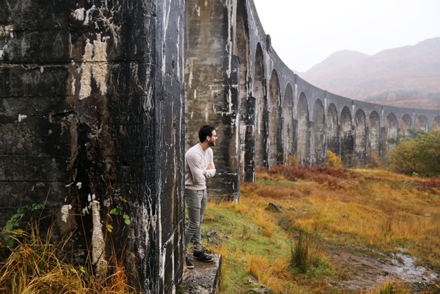 A DU student in front of some ruins, surveying the foggy landscape.