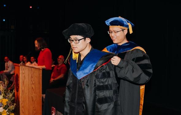 Ritchie School of Engineering and Computer Science student participating in our graduation hooding ceremony with faculty advisor