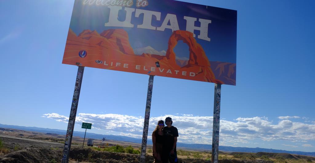 Aurora, her boyfriend, and dog at the Welcome to Utah sign