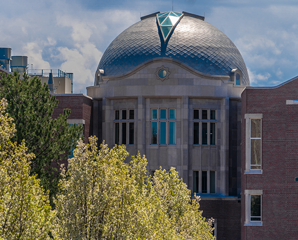 View of the Ritchie School Of Engineering and Computer Science with tree branches visible in the foreground.